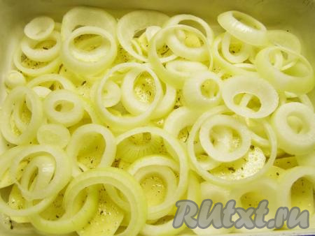 Лук чистим, нарезаем кольцами и выкладываем большую половину лука на картофель.