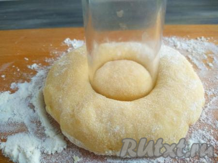 Рюмкой вырезать отверстие в центре лепёшки. Аналогично сформировать все бездрожжевые пончики.