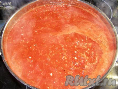 Остальную аджику в кастрюле ставим на сильный огонь и, периодически помешивая, доводим до кипения.