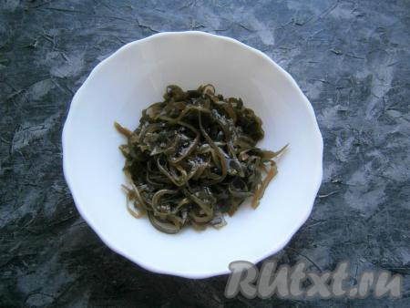 Яйца предварительно отварить вкрутую (на это потребуется 8-10 минут с начала закипания воды), остудить и очистить. Маринованную морскую капусту выложить в миску. Если капуста нарезана очень длинными полосами, их нужно немного измельчить.
