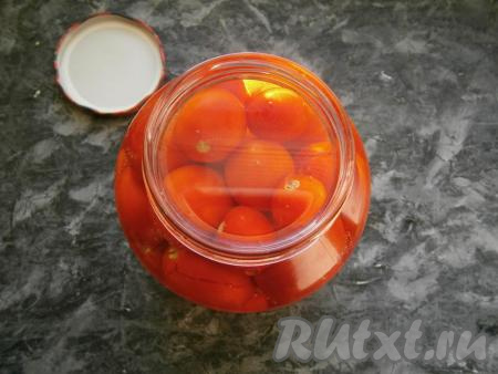 Заполнить банку небольшими помидорами, не слишком плотно. Залить помидоры крутым кипятком, прикрыть крышкой и оставить на 20 минут.