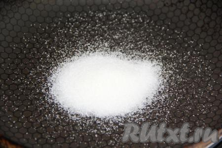 Заранее достать сливочное масло из холодильника, чтобы оно, полежав при комнатной температуре, стало мягким. В сковороду всыпать 1 столовую ложку сахара и, не перемешивая, растопить его на среднем огне.