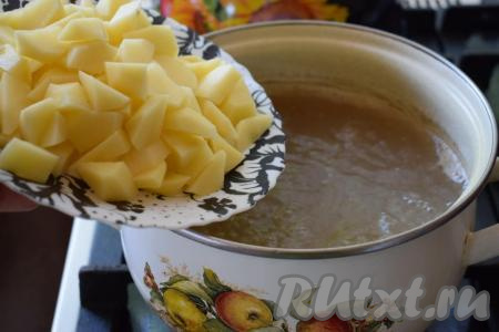 Из готового бульона достаём лук и зубчик чеснока (они нам больше не понадобятся). Извлекаем говяжьи кости и&nbsp;снимаем с них мясо. Говядину, отделённую от костей, мы будем добавлять в тарелку при подаче. Если в бульоне есть мелкие осколки костей, то бульон лучше процедить. В бульон добавляем очищенный и нарезанный на небольшие дольки картофель, ставим на огонь, даём закипеть и уменьшаем огонь.