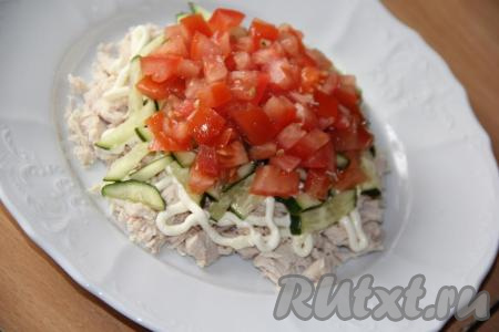 Помидор нарезать на кубики. Затем большую часть нарезанных помидоров выложить поверх огурца, слегка прижать.