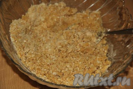 Добавить растопленное не горячее масло в смесь печенья и сахарной пудры, перемешать.