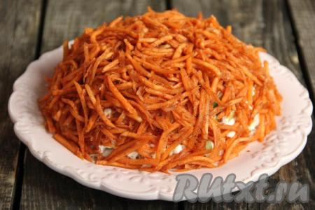 Затем выложить поверх салата морковь по-корейски и слегка её прижать по всей поверхности. Дать салату настояться пару часов в холодильнике и можно подавать это аппетитное блюдо к столу.