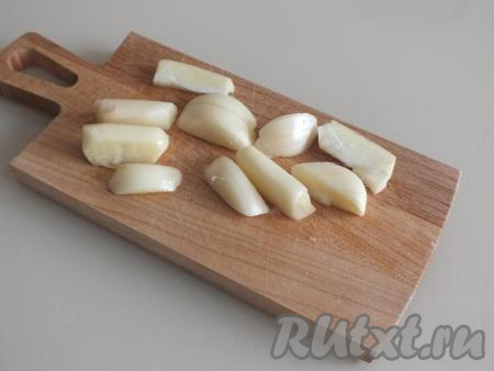 Зубчики чеснока очистите и разрежьте на части, из расчёта 1-2 кусочка на каждый помидор.