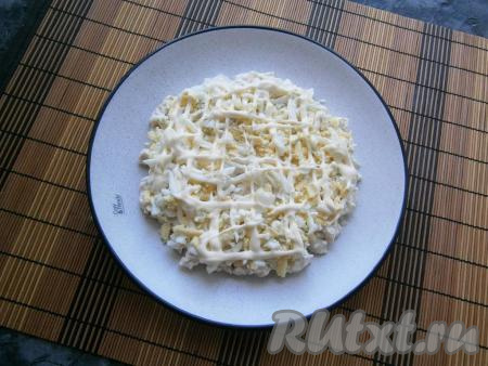 Следующим слоем выкладываем яйца, натёртые на крупной тёрке, сверху наносим&nbsp;сеточку&nbsp;из майонеза.