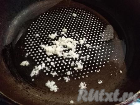 Чеснок очищаем и мелко нарезаем ножом. На сковороду вливаем растительное масло, выкладываем нарезанные зубчики чеснока и обжариваем на небольшом огне 2 минуты, помешивая.