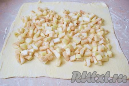 Яблочную начинку переложите на раскатанное тесто и распределите по всей поверхности, немного не доходя до краёв теста.