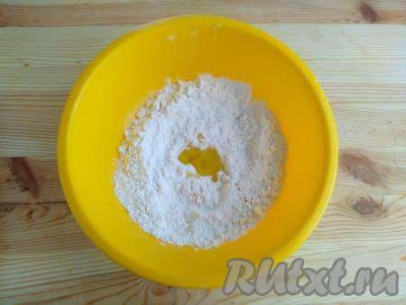 Сформировать по центру углубление, влить 1 столовую ложку растительного масла и 120 мл воды.