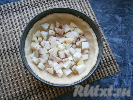 Тесто разделить на 2 части - одну большую, другую - меньшую. Большую часть теста раскатать и выложить на дно разъёмной формы диаметром 18-20 см, сформировав достаточно высокие бортики. Яблоки, очищенные от кожуры и семян, нарезать средними кубиками, выложить их в форму на тесто и посыпать молотой корицей.