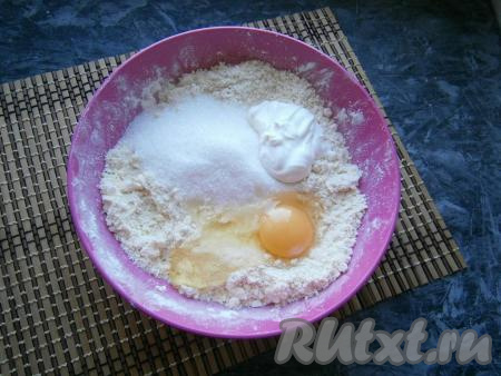 Перетереть муку с маслом руками в мелкую крошку, затем добавить сырое яйцо, 100 грамм сахара и сметану.