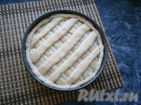 Из меньшей части теста сделать полосочки и закрыть ими крест-накрест весь пирог.