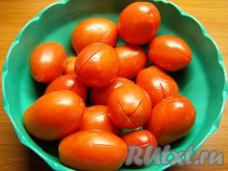 Помидоры хорошо моем и надрезаем кожицу каждого помидора крест на крест. Ошпариваем помидорчики кипятком, затем сразу опускаем в холодную воду.