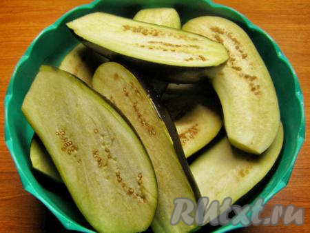 Баклажаны моем, отрезаем плодоножку и разрезаем вдоль на две части.