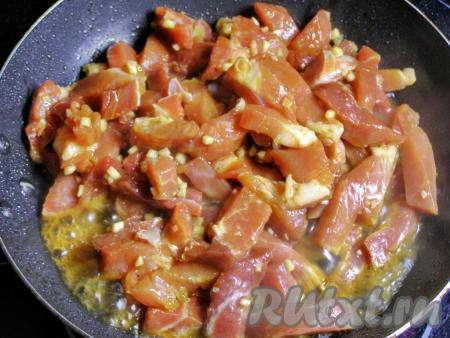 В другой сковороде разогреваем ещё одну столовую ложку подсолнечного масла и в горячее, почти раскалённое, масло осторожно выкладываем кусочки свинины. Маринад пока не добавляем. Обжариваем, постоянно перемешивая, на среднем огне, примерно, 5 минут. По желанию, можно немного поперчить.