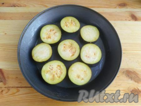 По истечении времени,&nbsp;смазать растительным маслом форму для запекания, выложить кружочки баклажана, отправить в разогретую духовку и запекать 10 минут при температуре 190 градусов.