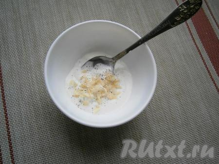 Сметану (или йогурт) выложить в пиалу, добавить измельчённый чеснок, чуть соли и чёрный молотый перец.