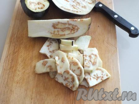 Пока кабачки с овощами обжариваются, баклажаны очистите от кожуры, а затем нарежьте кусочками толщиной 0,3 см.