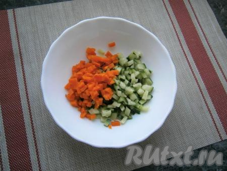 Свежий огурец и очищенную варёную морковку нарезать небольшими кубиками и выложить в миску.