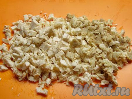 Варёную курицу достаём из бульона, оставляем немного остыть, затем отделяем от кожи и косточек. Куриное мясо мелко нарезаем.