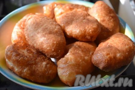 Готовые жареные пирожки снимаем со сковороды и выкладываем на тарелку. Пышные, румяные, такие вкусные и аппетитные пирожки с картошкой подаём к столу горячими. Хрустящая верхняя корочка, мягкое дрожжевое тесто и много ароматной начинки - ну как же это вкусно!