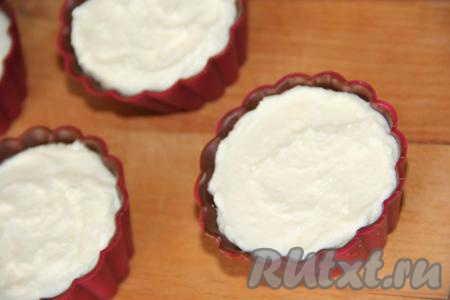 Однородную творожную массу выложить в формочки, заполняя их до краёв (творожная масса не должна быть выше бортиков застывшего шоколада).