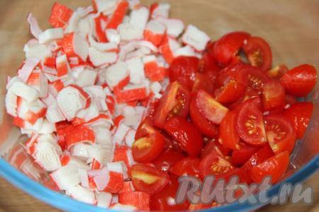 Вымыть помидоры и нарезать (помидорчики черри нужно разрезать пополам, если будете использовать более крупные помидоры, тогда&nbsp; разрежьте их на несколько частей). В салатнике соединить нарезанные крабовые палочки и помидоры.
