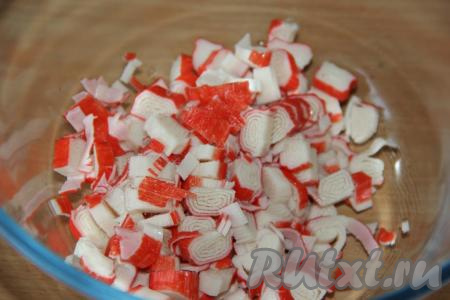 Разморозить крабовые палочки, дав им полежать при комнатной температуре, а затем снять слюду и нарезать их на кружочки толщиной 0,5 см.