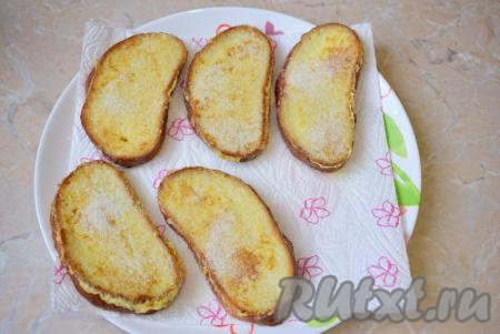 Готовые гренки сразу переложите со сковороды на бумажное полотенце, чтобы удалить с них остатки масла. Горячие гренки посыпьте немного сахаром.