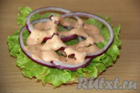 Для сбора бургера подготовить овощи: очищенную луковицу нарезать тонкими кольцами, огурцы и помидоры - тонкими кружочками.&nbsp;На нижнюю часть булочки нанести немного соуса и выложить лист салата. Разложить несколько колец&nbsp;лука. Нанести немного соуса.