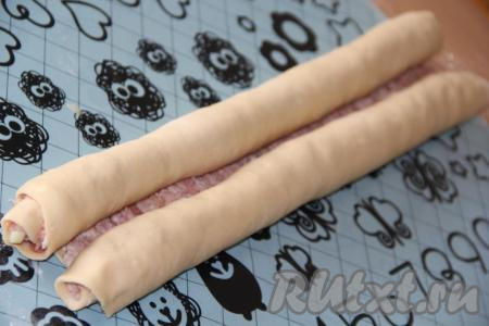 С двух сторон свернуть фарш в плотный рулет. Затем разрезать тесто в месте соединения. В&nbsp;итоге получатся&nbsp;2 отдельных рулета.