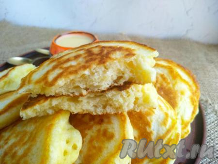 Оладушки переложить со сковороды на тарелку для подачи. Аналогично пожарить все оладьи из оставшегося теста, не перемешивая его. Пышные, аппетитные оладушки, замешанные на йогурте, можно подать со сгущённым молоком или мёдом. У этих оладий пористая структура, они долго не черствеют и сохраняют свои прекрасные вкусовые свойства.