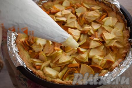 Вынимаем из духовки пирог с яблоками и хурмой. На его поверхность начинаем наносить белковый крем, отсаживая звёздочки (крем можно аккуратно разложить по верху пирога и с помощью ложки, обойдясь без кулинарного мешка и насадок).
