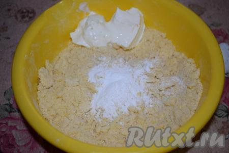 У нас должна получиться лёгкая, воздушная крошка. Добавляем к крошке разрыхлитель, сметану и замешиваем плотное песочное тесто.
