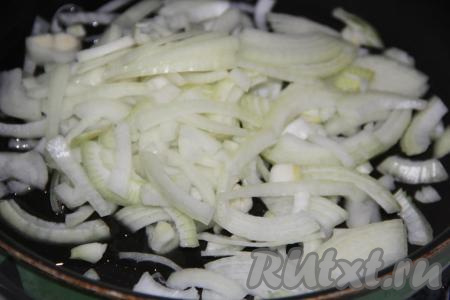 Лук почистить и нарезать тонкими полукольцами. В сковороду влить масло и добавить полукольца лука.&nbsp;