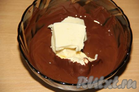 В растопленный тёплый шоколад выложить мягкое сливочное масло и перемешать до полного растворения масла.