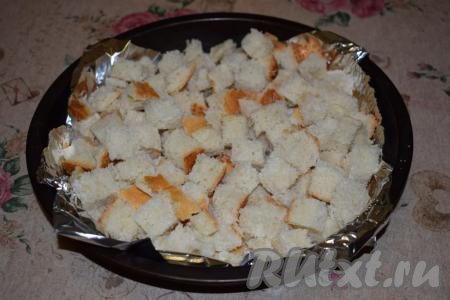 Форму для запекания (или противень) застилаем фольгой или пергаментом (делаем это для чистоты формы или противня, можно и не застилать). В форму выкладываем нарезанный кубиками батон.