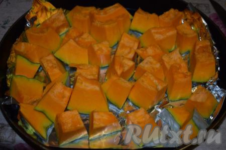 Тыкву, не очищая от кожуры, нарезаем на кусочки, примерно, равного размера. Форму для запекания (или противень) я застилаю фольгой, но можно этого и не делать. В форму (или на противень) выкладываем кусочки тыквы в один слой.
