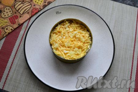 Далее идёт слой натёртого на средней тёрке сыра, посыпать мелко нарезанным чесноком.