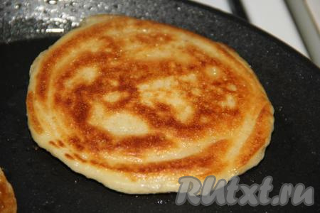 Выпекать толстый дрожжевой блин с двух сторон до золотистого цвета на среднем огне. Затем готовый блинчик переложить на тарелку, а из оставшегося теста аналогично приготовить все блины.