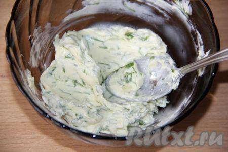 Перемешать сливочное масло с зеленью и чесноком с помощью ложки.