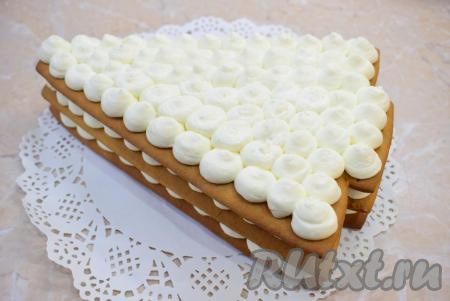 Поверх третьего коржа тоже отсадите крем. Собранный торт необходимо поставить в закрывающуюся тару, например, в коробку для торта,&nbsp;и убрать в холодильник на несколько часов, чтобы он хорошо пропитался. Закрытая тара необходима для того, чтобы вся влага от крема не испарялась, а пропитывала медовые коржи торта "Ёлочка".