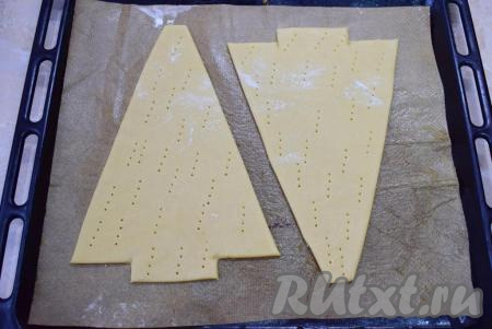 Каждую вырезанную ёлочку из теста наколите вилкой по всей поверхности. Это необходимо для того, чтобы тесто при выпечке не поднималось пузырями. Поставьте противень в духовку, разогретую до 180 градусов, на 5-7 минут. Медовые коржи пекутся очень быстро. Готовые коржи необходимо остудить.