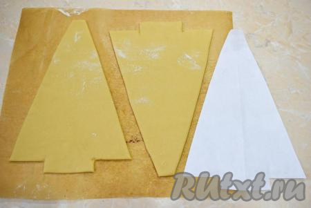 Тесто разделите на 3 части и раскатайте каждую на пергаменте для выпечки.&nbsp;На листе А4 нарисуйте трафарет ёлочки и вырежьте.  По трафарету из раскатанного теста вырежьте ёлочку. Всего должно получиться 3 ёлочки.