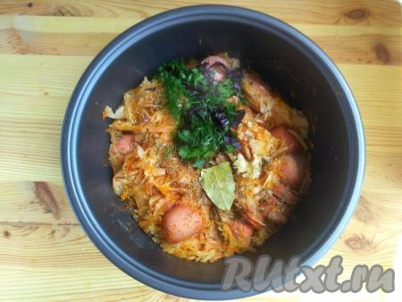 Зелень мелко порубить, чеснок пропустить через пресс. По окончании режима "Тушение" в чашу мультиварки к капусте с сосисками выложить чеснок, зелень, лавровый лист, специи (в качестве специй я использовала шалфей, хмели-сунели, паприку и чёрный молотый перец) и соль, перемешать, закрыть крышку мультиварки. Установить режим "Подогрев" на 10 минут.