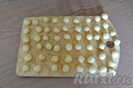 По истечении времени достаньте тесто из холодильника. Отщипните кусочек теста размером с фундук, скатайте из него шарик. Таким образом скатайте все шарики. Заготовки лучше подготовить заранее.