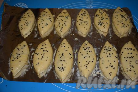 Сверху дрожжевые пирожки с капустой присыпаем кунжутом (я использовала белый и чёрный кунжут).