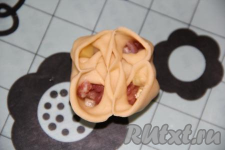 Углы получившегося конвертика соединить между собой и защипнуть снаружи. Должен получиться мант, по форме похожий на цветок. Вот такой у меня цветочек получился.